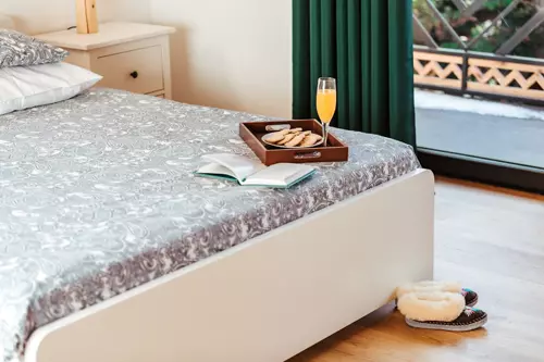 Łoże, książka, kapcie góralskie, taca z sokiem oraz ciasteczkami