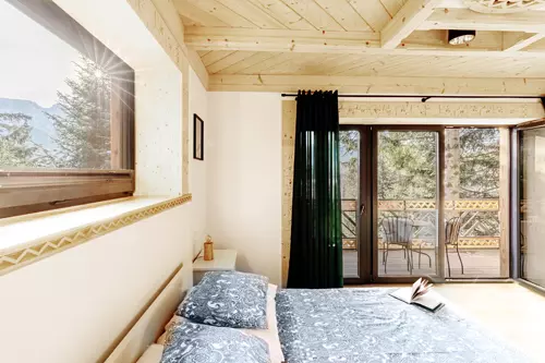 Duża sypialnia, widok na łóżko, Tatry oraz taras ze stolikiem kawowym