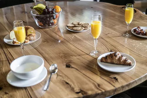 Drewniany stół, na stole śniadanie